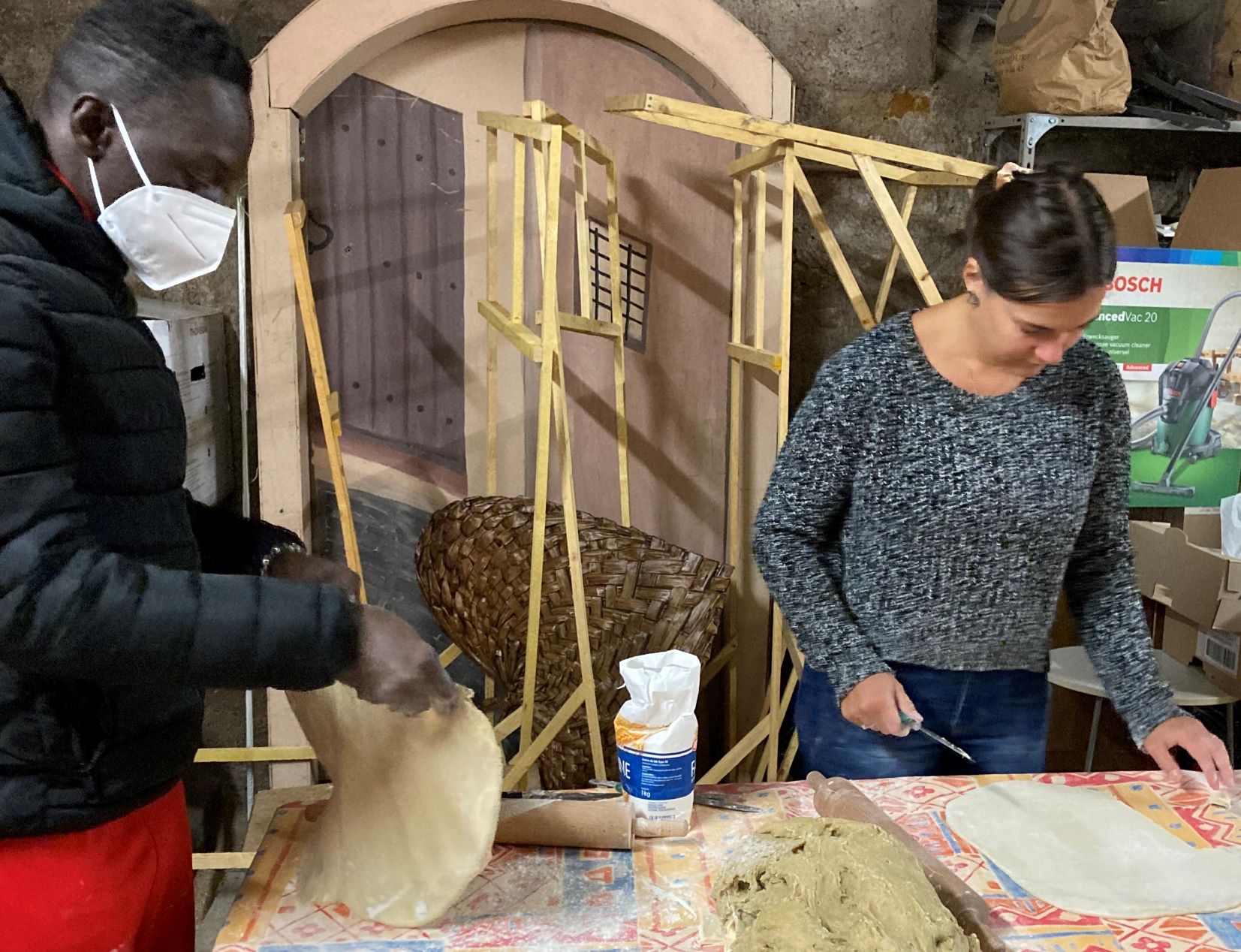 Une jeune administratrice préparait la pâte pour les gaufres avec un jeune volontaire.