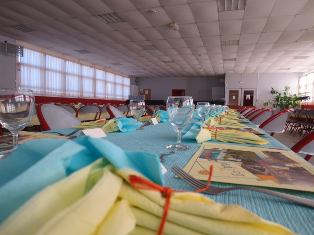 Des tables en pastels bleus et jaunes, avec pour chacun un set de table aux couleurs de l'association