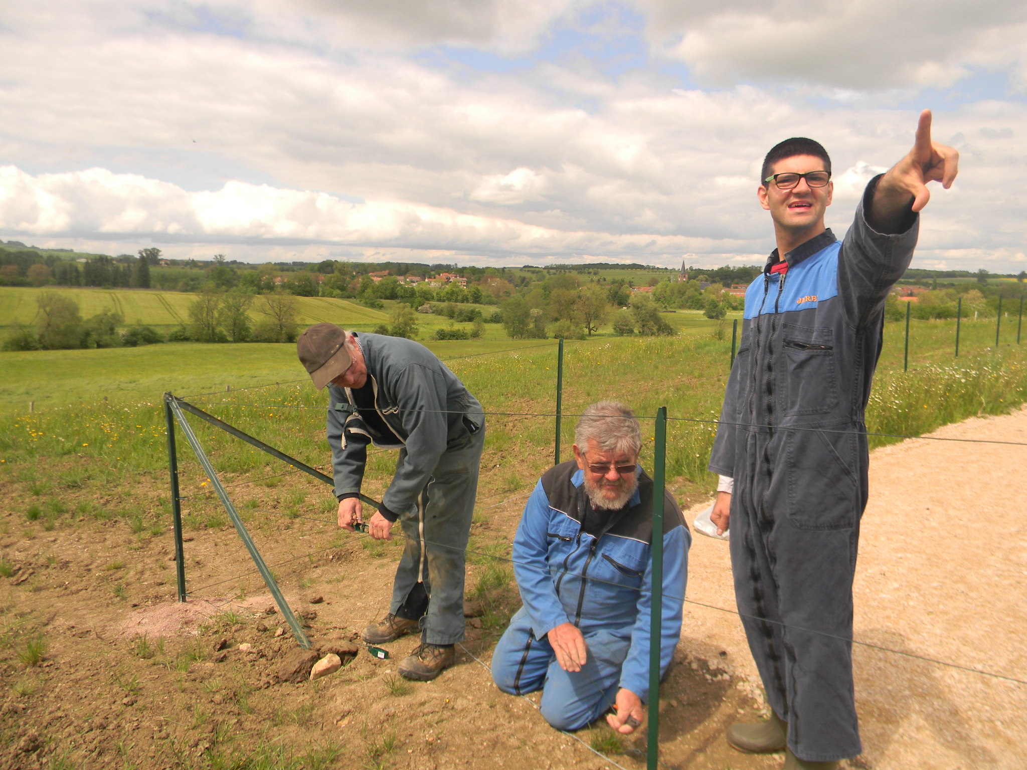 Sous les ordres de Jérémy, Pierre et Bernard s'affèrent à installer la clôture.